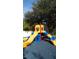 Colorful playground with slides and climbing structures beneath the shade of a large tree at 5364 Diplomat Ct # 106, Kissimmee, FL 34746