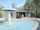 A community pool featuring a mushroom-shaped fountain with the clubhouse in the background providing a resort-style living experience at 5364 Diplomat Ct # 106, Kissimmee, FL 34746