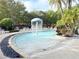 A community pool featuring lounge chairs and a mushroom-shaped water fountain amid lush landscaping, creating a relaxing atmosphere at 5364 Diplomat Ct # 106, Kissimmee, FL 34746