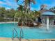 A community pool features tropical landscaping, a mushroom fountain, and a ladder for access, creating a luxurious and relaxing environment at 5364 Diplomat Ct # 106, Kissimmee, FL 34746