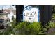 Lucaya Village sign surrounded by lush landscaping and colorful flowers at 5364 Diplomat Ct # 106, Kissimmee, FL 34746