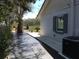 Side view of home with brick and AC unit. Landscaping includes trees and various plants at 539 Libby Rd, Babson Park, FL 33827