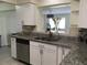 Updated kitchen boasts stainless steel appliances, granite countertops, and a window view to the living area at 539 Libby Rd, Babson Park, FL 33827