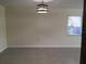 Light and airy living room with neutral walls, stylish lighting, and large window at 539 Libby Rd, Babson Park, FL 33827