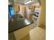 Well-lit kitchen featuring ample counter space, stainless steel sink, modern appliances, and durable tile flooring at 5968 Westgate Dr # 101, Orlando, FL 32835