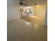 Expansive living area featuring durable tile flooring, ceiling fan, and seamless transition into an open-concept kitchen at 5968 Westgate Dr # 101, Orlando, FL 32835
