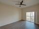 Bedroom features a ceiling fan, wood floors, and sliding glass doors to a balcony at 709 Lucaya Loop # 1203, Davenport, FL 33897