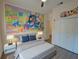 Fun bedroom featuring themed mural, hardwood floors, closet and decor at 709 Lucaya Loop # 1203, Davenport, FL 33897