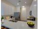 Well-lit modern kitchen with stainless steel appliances, white cabinets, and laminate floors at 709 Lucaya Loop # 1203, Davenport, FL 33897