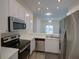 Modern kitchen boasting stainless appliances, white cabinets, and laminate floors at 709 Lucaya Loop # 1203, Davenport, FL 33897