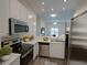 Bright white kitchen with stainless appliances and sleek countertops, open to the living area at 709 Lucaya Loop # 1203, Davenport, FL 33897