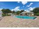 Community pool with a brick deck, cabana, and lounge chairs on a sunny day at 7125 Harmony Square Dr # 2, Harmony, FL 34773