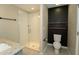 Modern bathroom with a tiled, glass enclosed shower, toilet and floating shelves at 751 Jefferson St, Davenport, FL 33837