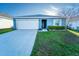 Charming single-story home with a well-manicured front lawn and a two-car garage in a residential neighborhood at 751 Jefferson St, Davenport, FL 33837