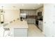 Well-lit kitchen features stainless appliances, light gray cabinetry, granite countertops and tile flooring at 751 Jefferson St, Davenport, FL 33837