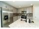 Bright kitchen featuring granite countertops, stainless appliances, subway tile backsplash, and gray cabinetry at 751 Jefferson St, Davenport, FL 33837