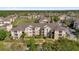 Wide aerial view of the apartment complex showcasing manicured lawns, mature trees, and ample parking at 8103 Coconut Palm Way # 205, Kissimmee, FL 34747