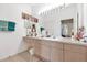 Bright bathroom features light wood cabinets, double vanity, and a large mirror with vanity lighting at 8103 Coconut Palm Way # 205, Kissimmee, FL 34747
