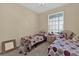 Bedroom with two twin beds, a central nightstand, and a large window with natural light at 8103 Coconut Palm Way # 205, Kissimmee, FL 34747