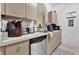 Compact kitchen featuring stainless steel dishwasher and light wood cabinets and neutral countertops at 8103 Coconut Palm Way # 205, Kissimmee, FL 34747
