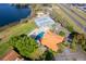 Aerial view showcases a community pool, tennis courts, and lakeside amenities at 8507 Waterview Way, Winter Haven, FL 33884