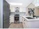 Well-equipped kitchen with stainless steel appliances, white cabinets, quartz countertops, and a bright skylight at 8507 Waterview Way, Winter Haven, FL 33884