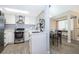 Modern kitchen with stainless steel appliances, white cabinetry, and a view of the adjacent dining area at 8507 Waterview Way, Winter Haven, FL 33884