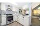 Modern kitchen with stainless steel appliances, white cabinetry, and an inviting view into the dining area at 8507 Waterview Way, Winter Haven, FL 33884