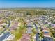 Expansive aerial view shows a desirable neighborhood with mature trees, lush landscaping, and community pond at 1004 Costa Mesa Ln, Kissimmee, FL 34744