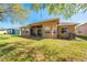 Spacious backyard with lush lawn, mature trees, and a covered patio ideal for outdoor living at 1004 Costa Mesa Ln, Kissimmee, FL 34744