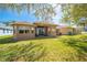 Large backyard showcasing a well-maintained lawn and a covered patio for outdoor enjoyment at 1004 Costa Mesa Ln, Kissimmee, FL 34744