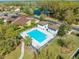 Aerial view featuring a sparkling community pool with cabana and ample seating, surrounded by lush landscaping at 1004 Costa Mesa Ln, Kissimmee, FL 34744