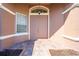 A close-up view of a double-door entry featuring a decorative transom window and brick pathway, creating an inviting entrance at 1004 Costa Mesa Ln, Kissimmee, FL 34744