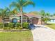 Charming single-story home featuring a well-maintained lawn and lush landscaping, complete with a paved driveway and front walkway at 1004 Costa Mesa Ln, Kissimmee, FL 34744