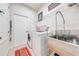 Functional laundry room equipped with modern appliances, a sink, and storage shelves at 1004 Costa Mesa Ln, Kissimmee, FL 34744