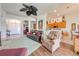 Open-concept living room featuring hardwood floors, a ceiling fan, and views into the kitchen area at 1004 Costa Mesa Ln, Kissimmee, FL 34744