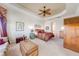 Cozy main bedroom featuring a tray ceiling, a ceiling fan, and warm lighting at 1004 Costa Mesa Ln, Kissimmee, FL 34744