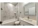 Bathroom with a tub, a white vanity, marble tile, and modern fixtures at 1013 Cannes Dr, Kissimmee, FL 34759