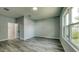 Bright bedroom featuring wood-look floors, neutral paint, and a window showcasing the outdoor view at 1013 Cannes Dr, Kissimmee, FL 34759