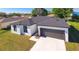 A modern, one-story home featuring a gray roof, a two-car garage, and well-maintained landscaping at 1013 Cannes Dr, Kissimmee, FL 34759