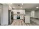 A spacious kitchen featuring stainless steel appliances, white cabinetry, and hardwood floors at 1013 Cannes Dr, Kissimmee, FL 34759