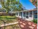 Backyard featuring a well-maintained lawn, brick pathway, a lush garden, and a sunroom with windows at 103 W Maple St, Davenport, FL 33837