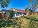 Backyard view of the home featuring a sunroom with lots of windows, brick exterior, and mature trees at 103 W Maple St, Davenport, FL 33837
