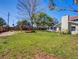 View of the large, grassy backyard with a gazebo, mature trees, and the rear of the house at 103 W Maple St, Davenport, FL 33837