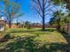 Fenced backyard with a green lawn, shade trees, and a gazebo at 103 W Maple St, Davenport, FL 33837