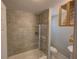 Bright bathroom featuring tiled walls, tub with shower, and open shelving with clean, neatly folded towels at 103 W Maple St, Davenport, FL 33837