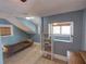 Attic bedroom with light blue walls, laminate floors, and an interesting window at 103 W Maple St, Davenport, FL 33837