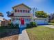 Charming two-story home featuring a red front door, attached garage, and a well-manicured lawn at 103 W Maple St, Davenport, FL 33837