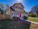 Charming two-story home boasting a red front door, mature trees, and an attached garage at 103 W Maple St, Davenport, FL 33837