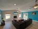 Spacious living room with a white brick fireplace, modern furniture, and natural light at 103 W Maple St, Davenport, FL 33837
